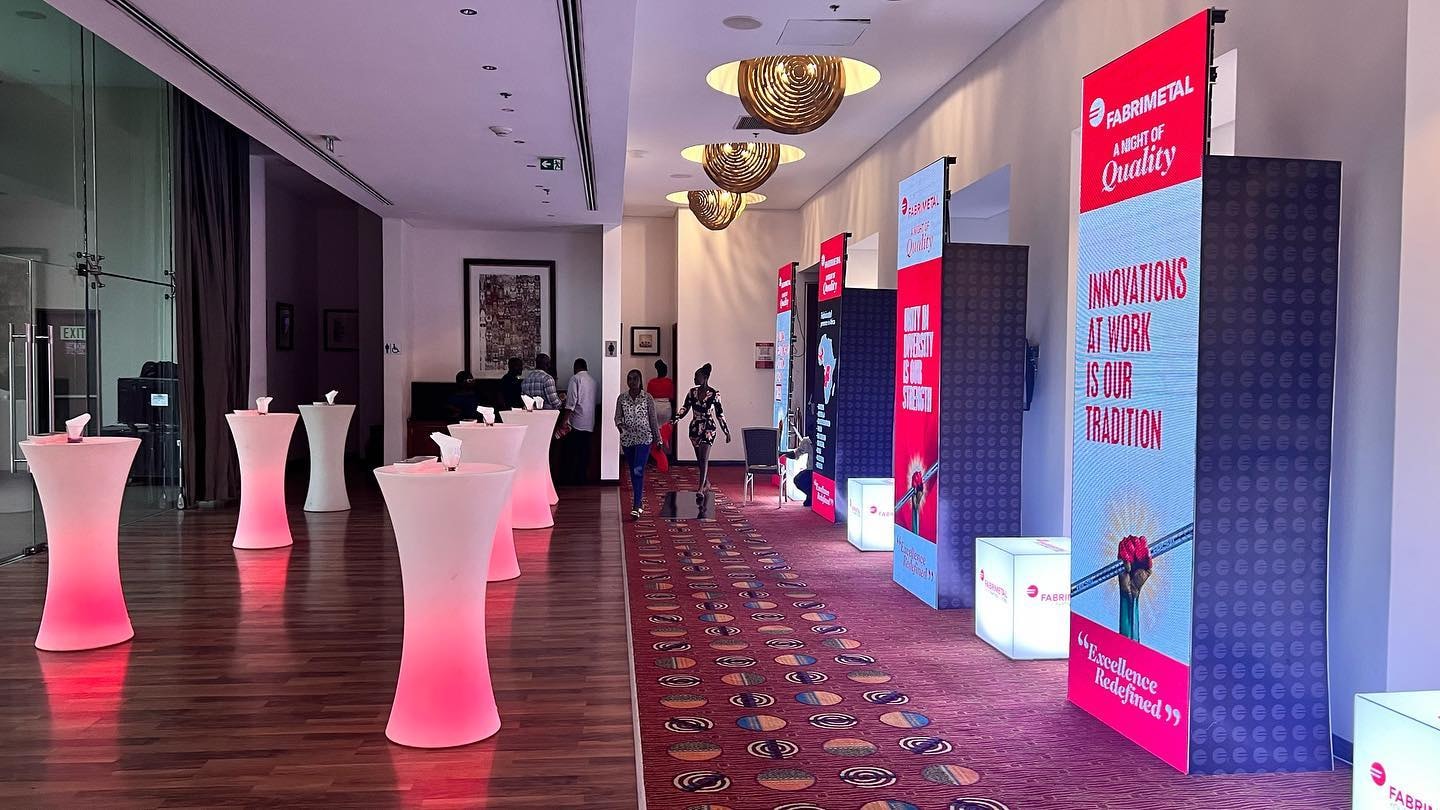 Indoor reception with cocktail tables and a red LED stage